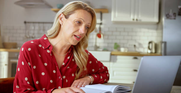 istock Woman having a video call on laptop in kitchen 1313800677