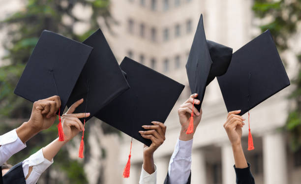 istock Cropped of students raising up hands with caps 1313800707
