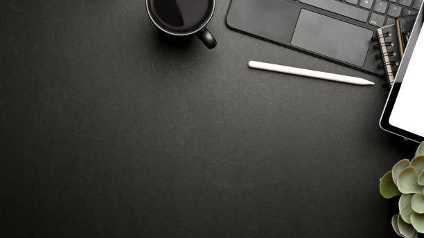 istock Dark creative mock up scene with tablet, accessories, mug and copy space 1313800889