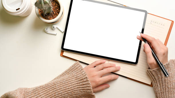 istock Top view of female working with digital tablet and notebook on white table 1313801162