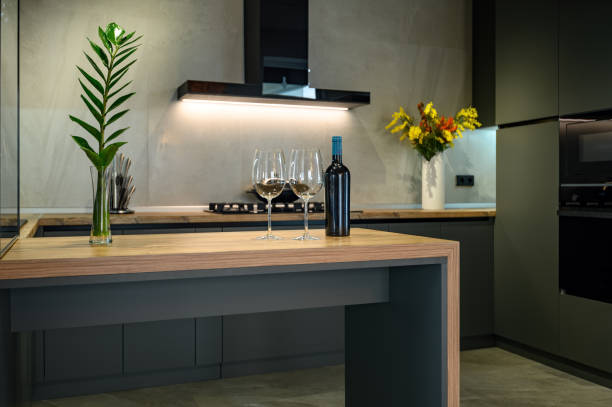 Modern large luxurious studio apartment with kitchen Modern luxury loft studio apartment interior with dark grey kitchen bar cabinet stock pictures, royalty-free photos & images