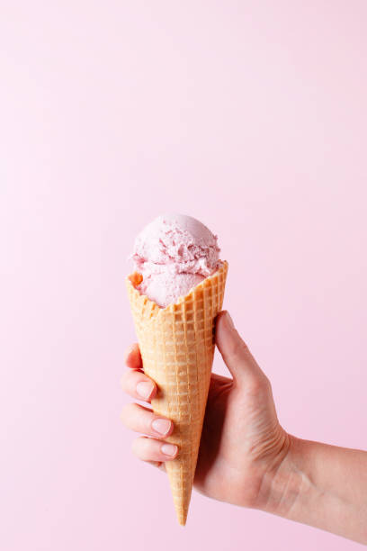 istock Female hand holding the ice cream, pink background 1313801598