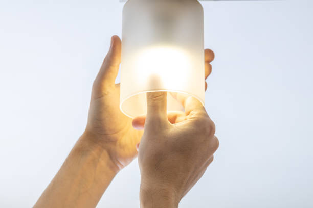 istock handyman replacing light bulb at wall lamp. changing light equipment for more energy efficient concept. electricity save conceptual 1313801809