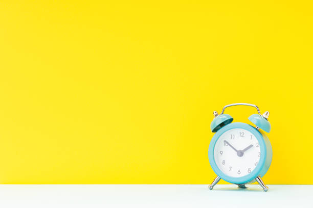 istock blue alarm clock over yellow background. studio shot. time concept. template for design 1313801856