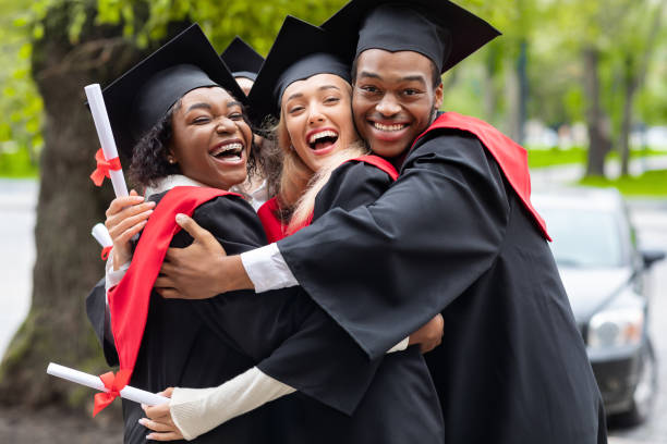 istock Black guy and two young ladies in graduation costumes 1313802942