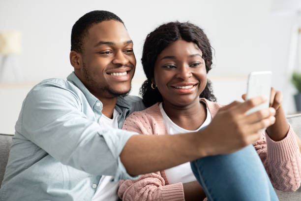 istock Cheerful african american couple taking selfie, using smartphone 1313802971