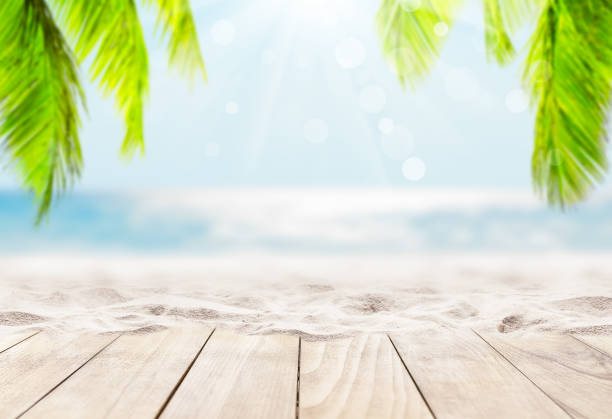 istock Wooden table top on blue sea and white sand beach background. 1313804504