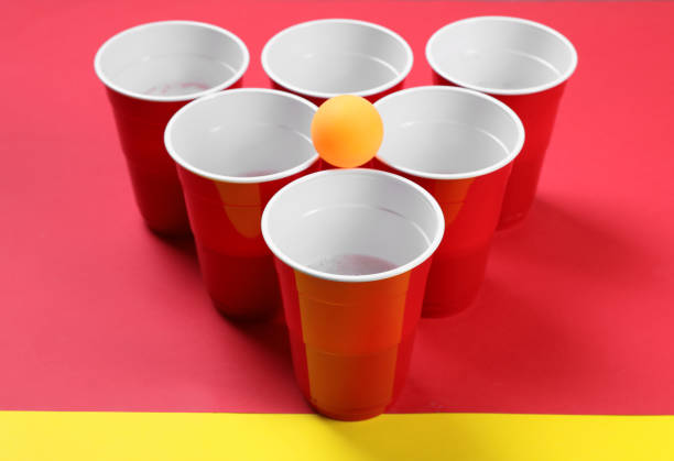 istock Plastic cups and ball for beer pong on color background 1313805192