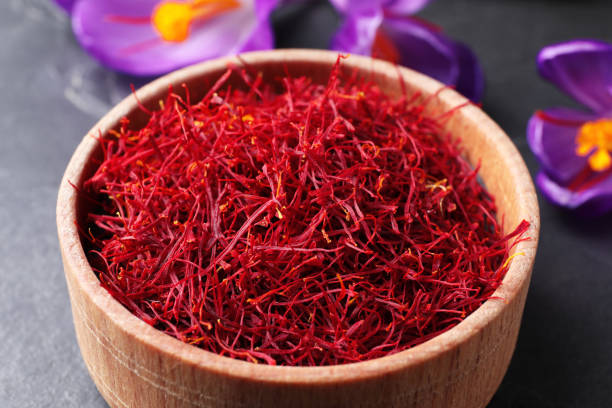 istock Dried saffron in bowl and crocus flowers on table, closeup 1313805819