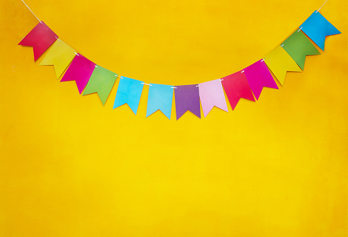 Colorful festive garland on yellow background