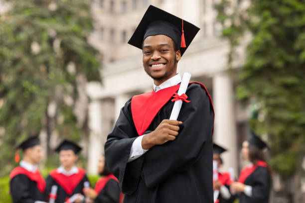 istock Cheerful african american guy in graduation costume 1313808936