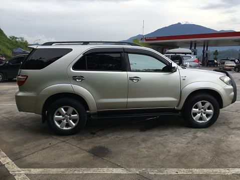 The side view of private Toyota Fortuner SUV Car on road in Semarang, Indonesia