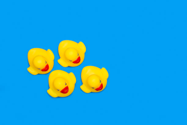 istock Four yellow rubber toy ducks on a yellow background 1313814980