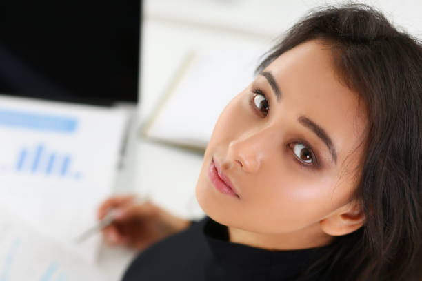 istock Portrait of young brunette woman with documents on table 1313815444