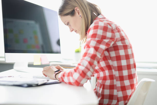 femme penché tapant sur le clavier d’ordinateur à la table - hump photos et images de collection
