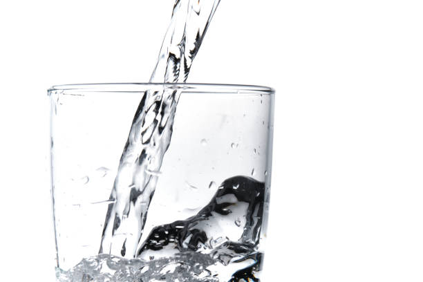 istock A glass being filled by water on a white background 1313816666