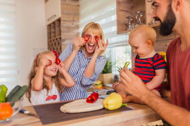 istock Mother and daughter having fun while cutting vegetables for lunch 1313817792