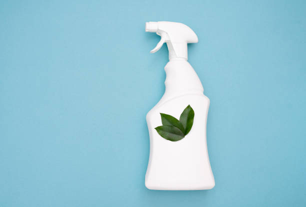 istock White spray bottle with green leaves on a blue background. Eco-cleaning 1313819030