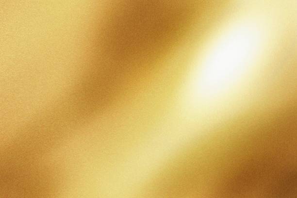 istock Light shining on gold painted metal sheet with copy space, abstract texture background 1313820374