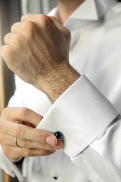 istock Groom putting on cufflinks as he gets dressed 1313821537
