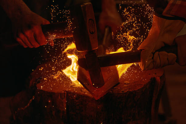 istock Blacksmiths hit molten metal with hammers close up 1313822102