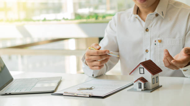 istock Real estate agents are introducing house forms and contract documents with a laptop on their desk. 1313823737