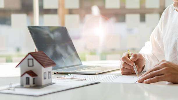 istock Real estate agents are introducing house forms and contract documents with a laptop on their desk. 1313823745