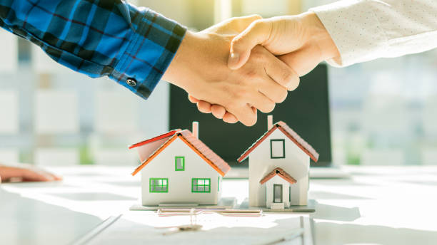 istock Real estate agents join hands with clients to introduce house designs and contract documents with laptops on their desks. 1313823752