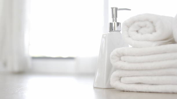 istock close up ofTowel placed on basket, white table top, bottle of liquid soap, spa set for bathing in the bathroom, copy space, bathroom window. 1313824564