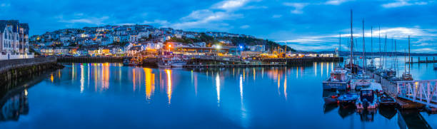 istock Fishing village warmly illuminated at dusk panorama Brixham Devon UK 1313826228