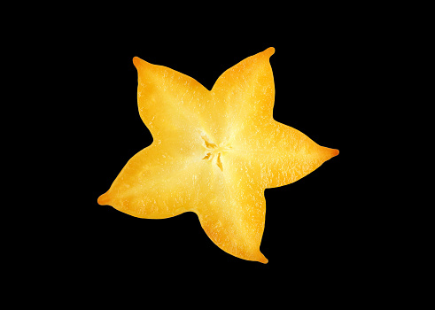 Closeup of fresh ripe star fruit cross section isolated on black background