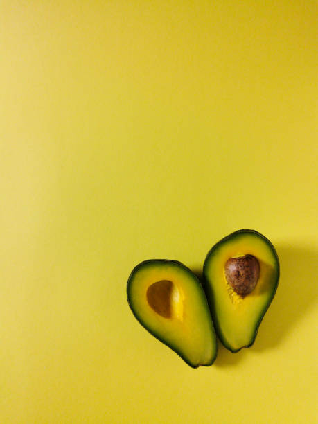 istock Ripe cut avocado lies on a yellow background 1313836744