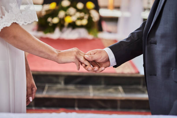 istock Newlyweds hold hands during a wedding in a catholic church 1313837129