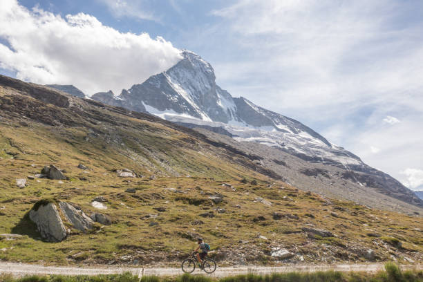 istock Man mountain biker rides on trail below the Matterhorn mountain 1313837886