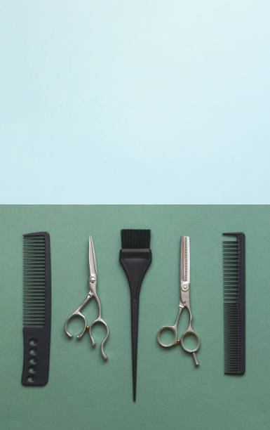istock Hairdressing tools scissors, combs and brush on green and blue background with copy space. Vertical template for hair salon 1313838035
