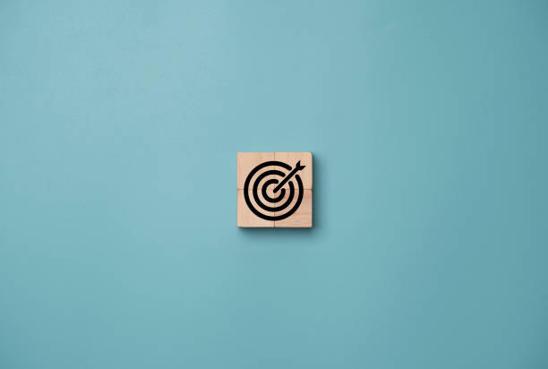istock Center Virtual target board on blue background and arrow which print screen on wooden cube. Business achievement goal and objective target concept. 1313838784