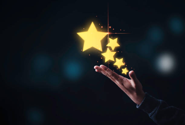 istock Hand showing five yellow gold stars on black background , Customer satisfaction and evaluation product and service concept. 1313838949