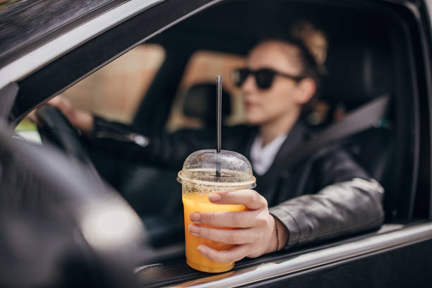 istock Woman drinking juice and driving car 1313839581