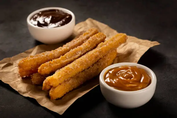 Traditional churros with sugar and chocolate sauce.