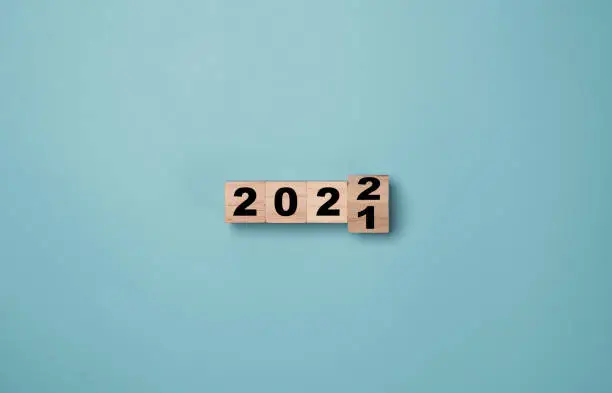 Flipping of wooden cubes block to change 2021 to 2022 year. Merry Christmas and happy new year concept.