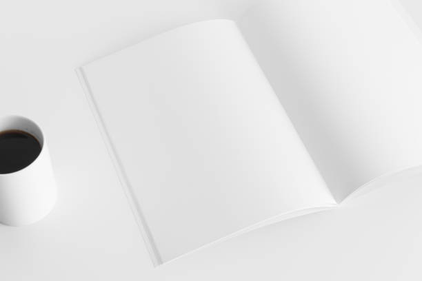 istock Open magazine mockup with a cup of coffee  on the white table. 1313842583
