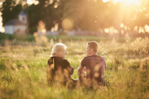 istock Mother sitting with son on meadow at sunset 1313844278