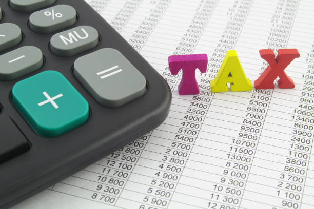 istock Word TAX and calculator on financial documents. 1313846577