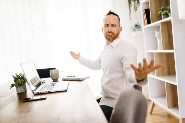 istock frustrated and sad man working on laptop at home 1313847043