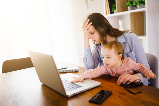 istock sad and frustrated mother in kitchen home office with computer and her daugher 1313847151