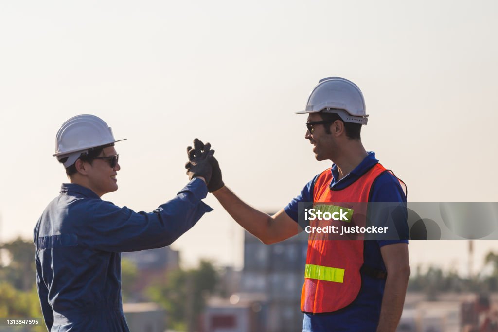 Engineer and worker soul brother handshake, thumb clasp handshake or homie handshake, Happy foreman team join hands together, Success and Teamwork concepts Honesty Stock Photo