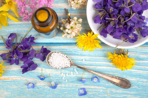 istock Homeopathy globules and blossoms on a table with spoon and globules 1313851021