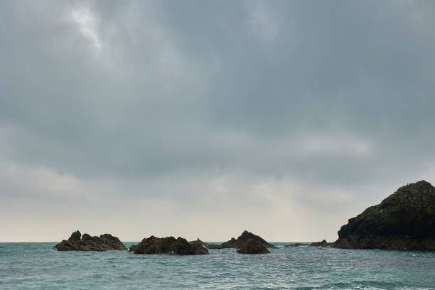istock rocks in Atlantic ocean surrounded by water and with cloudy sky. 1313851809