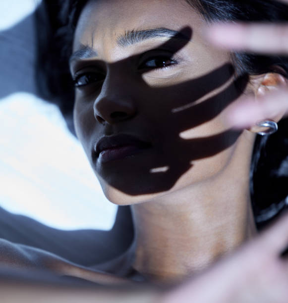 istock Shot of a young woman shielding her face from a bright light 1313851920