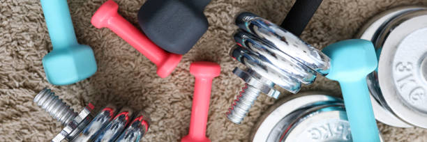 istock Pile of shiny chrome dumbbells disks lying around grip 1313853025